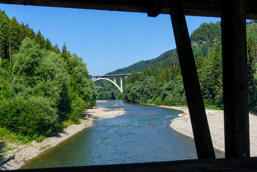 Blick von einer Fahrradbrücke über die Mur auf die Murbrücke Frojach