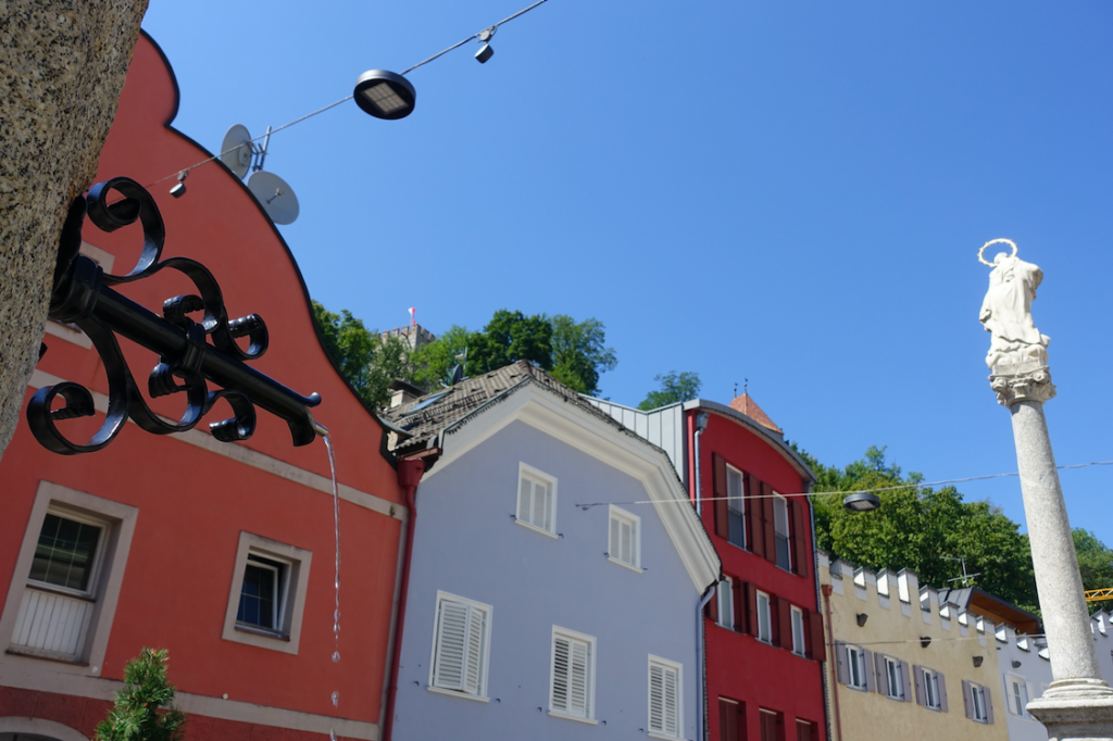 Der zentrale Brunnen in Brunneck mit Blick auf das Schloss hoch oben