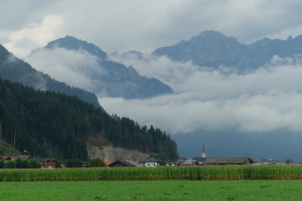 Zurück aus dem Zillertal zum Inn vor wolkenverhangenen Bergen (links Ebner Joch – 1.957 m, dahinter der Rofan-Hauptkamm – bis 2.299 m)